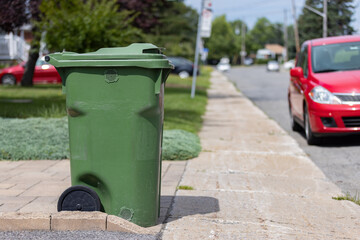 Green container for recycling or compost by the side of the street - 525953208