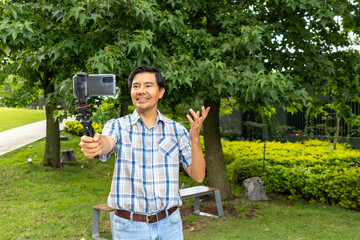 Influencer streaming live in a park. Social media concept
