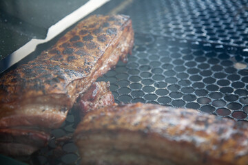 Meat on the grill roasting, smoky. Writing space.