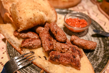Cevapi or cevapcici. Traditional meat dish in Balkans. Meat prepared on barbecue and served with...