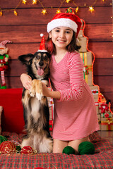 Obraz premium brazilian child celebrating christmas with smiling mutt dog vertical photo