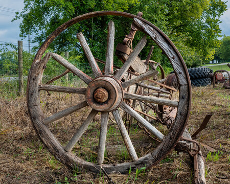 Weathered old cracked and rusted wooden spoked wagon wheel.