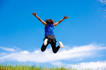 スポーツウエアを着て土手でジャンプする女性