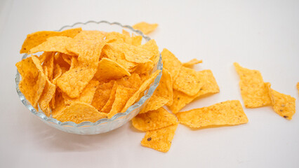 Delicious nachos chips on the glass bowl, isolated on white background