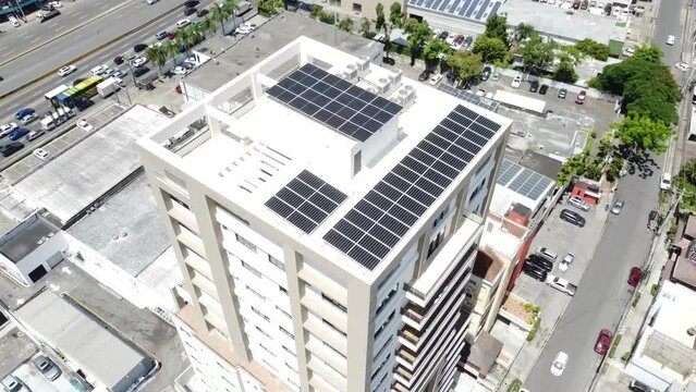 Toma de drone captando paneles solares en alto edificio residencial, concepto energia renovable