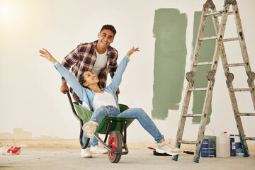 Love, teamwork and renovation, couple paint a wall in a house green. Happy, creative and playful,...