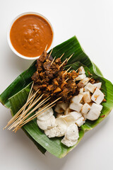 sate padang, indonesian cuisine padang beef, intestine satay with spicy peanut sauce and rice cake,...