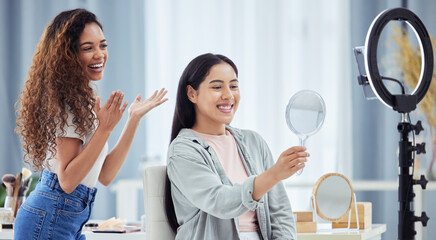 Woman recording a makeup tutorial with a client for her beauty blog or vlog using her phone at...