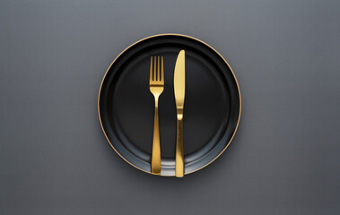 Gold knives and forks on a black background, empty black plate. Beautiful gold cutlery.