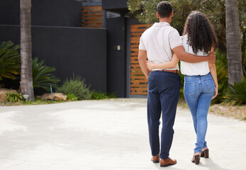 Property, real estate and new home with a man and woman homeowner looking at their house together outside. Property, real estate and an investment in their future with a couple standing on a driveway - obrazy, fototapety, plakaty
