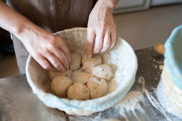 The process of making traditional French bread in a craft bakery. Molding of the Bordeaux crown. Front view.