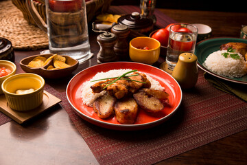 Fried chicken stew with baked potatoes Peruvian comfort restaurant gourmet food