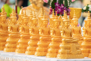 Golden Buddha statues placed on the white table, which were wet by rain felled and prepared for a religion ceremony event.