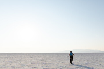Young woman riding a bike on Bonneville Salt Flats in Utah