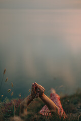 girls hands holding a wild flower on the background of the sea
