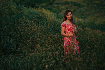 portrait of young woman in summer in tall grass