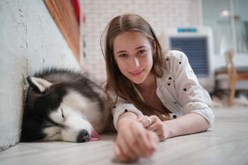 Young woman with her dog at modern house on nature light.