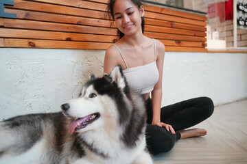 Young woman with her dog at modern house on nature light.