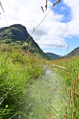Kleiner Gebrigsbach fließt durch das Tal Glen Coe in den Schottischen Highlands, Glencoe, Argyll, Schottland - obrazy, fototapety, plakaty