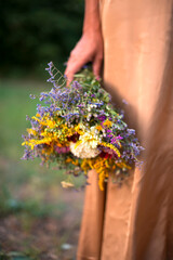 bouquet of wild flowers in hand. summer background