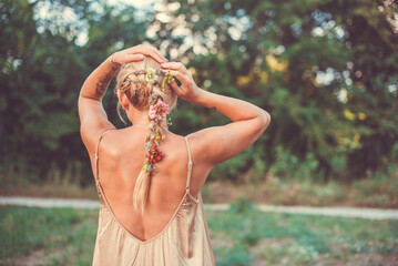 The blonde fixes her hair. Flowers in your hair. Summer mood
