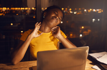 Neck pain, studying hard and work stress of a young female student working late for a test or exam. Stressed, tired and anxious preteen girl work at night on a school study class project inside
