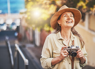 Happy photographer tourist taking photo of historic building with camera, smiling and carefree. Excited mature female solo travel journey, enjoying retirement while looking at bucket list destination - obrazy, fototapety, plakaty