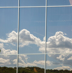 The sky is reflected from the glass showcase, the background of the facade.