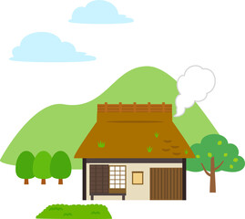Obraz na płótnie Canvas 排煙している茅葺屋根の家と山の風景