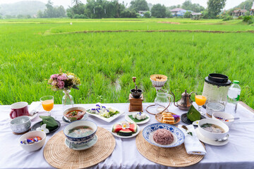 Breakfast, porridge, fruit salad, not dessert and drip coffee are placed on the terrace overlooking...