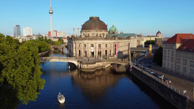 Boat on river house reflected in Spree water, Train.
Calm aerial view flight fly forward drone footage
of berlin Bode Museum island at summer day sunset July 2022. Marnitz 4k Cinematic view from above