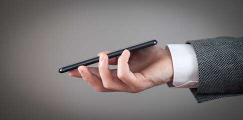 Caucasian man holding smartphone at home.