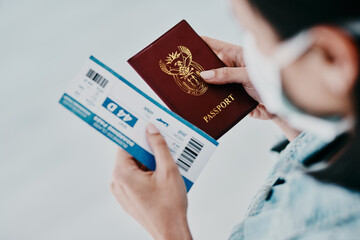 Travel, covid and tourist visa or passport while holding a plane flight ticket with face mask at...