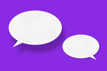 White paper in the shape of speech bubbles against a purple background. communication bubbles