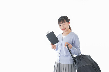 ガイドブックを持ち一人旅をする若い女性