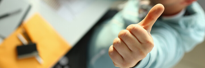 Young designer holding thumb up gesture closeup