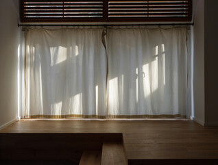 sunlight shining on closed white fabric curtain in loft flat.