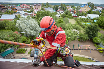 A specialist is repairing the roof. Rope access