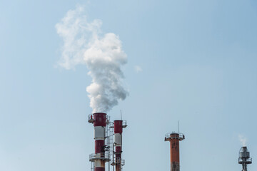 Air pollution by smoke coming out of two factory chimneys.