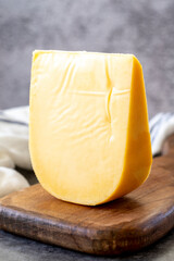 Yellow gouda cheese. Hard Dutch gouda cheese, on dark background. close up