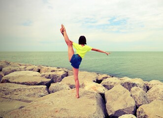 slender girl on the rocks with old toned effet