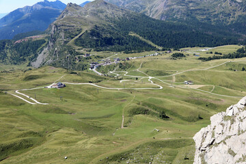 view of the Alpine Pass called Passo Rolle from above in summer with green grassy meadows