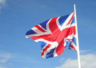 waving United Kingdom UK flag on blue sky background