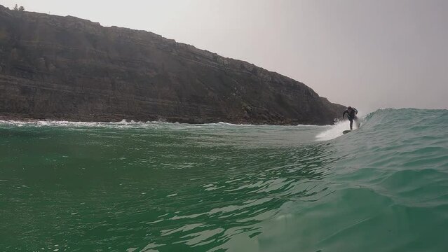 Surfer surfing ocean wave in Aguda beach Portugal