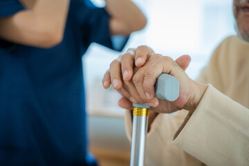 Nurse helps senior man practice walking at nursing home,Caregiver serve physical therapy for older patient to exercise and practice walking on walker or cane.