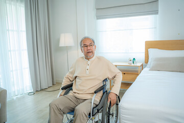 Senior man are using wheelchair for motion after doing physical therapy alone at home.
