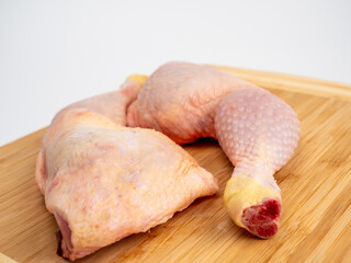 Raw chicken legs on a cutting board. Chicken legs on a white background.