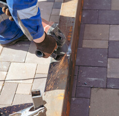 A worker cuts metal at a construction site.