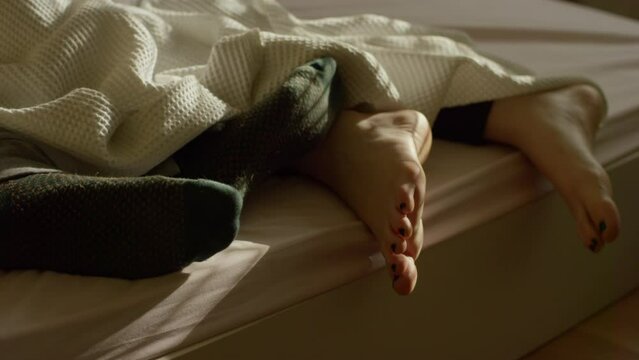 P&eacute;s de casal deitados na cama