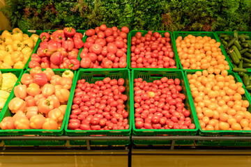 Supermarket vegetables background. Fresh tomatoes and peppers in boxes on the supermarket counter. Food, grocery, agriculture concept